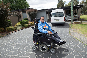 Boy in wheelchair outside his home